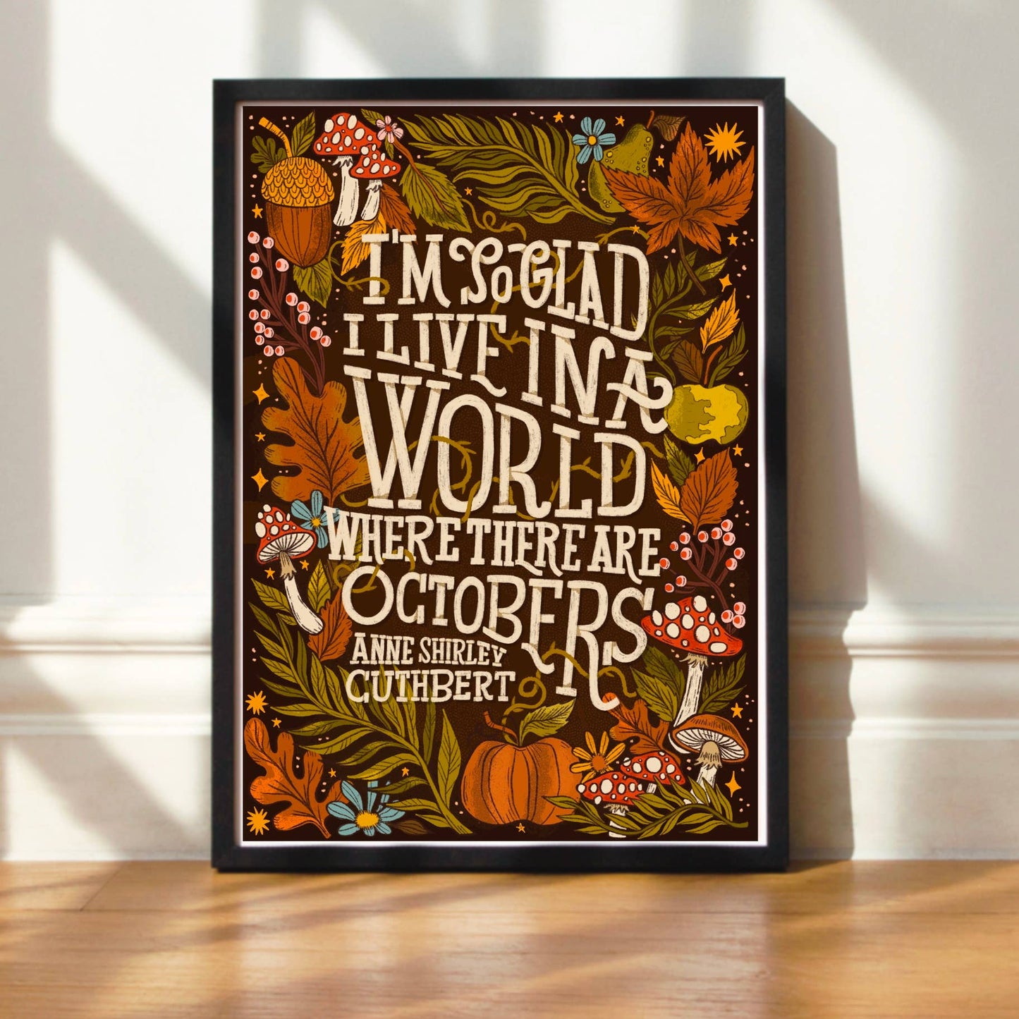 Decorative print with autumn-themed design and text on a wall.