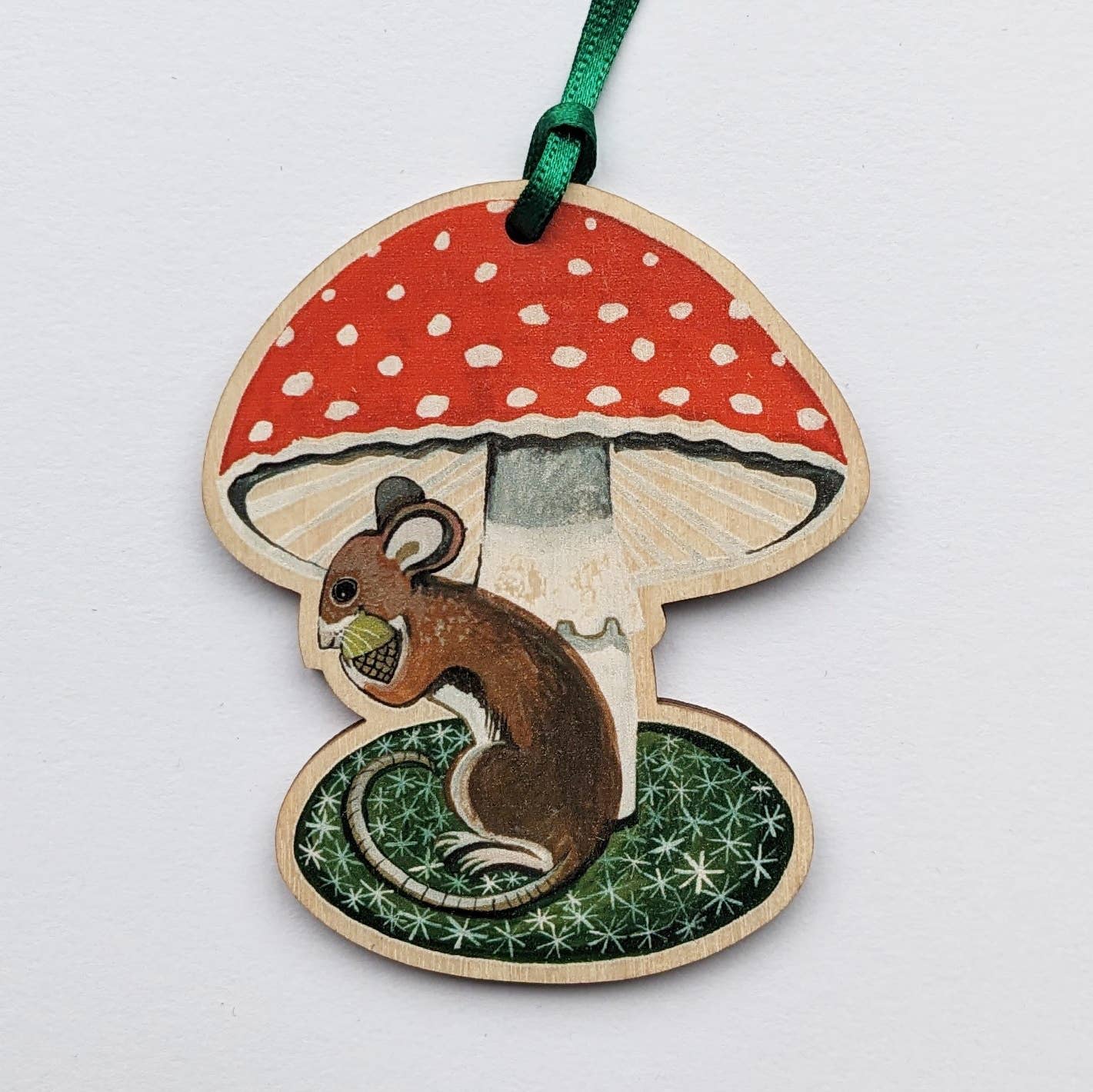Wooden ornament with a red mushroom and a squirrel on a white background