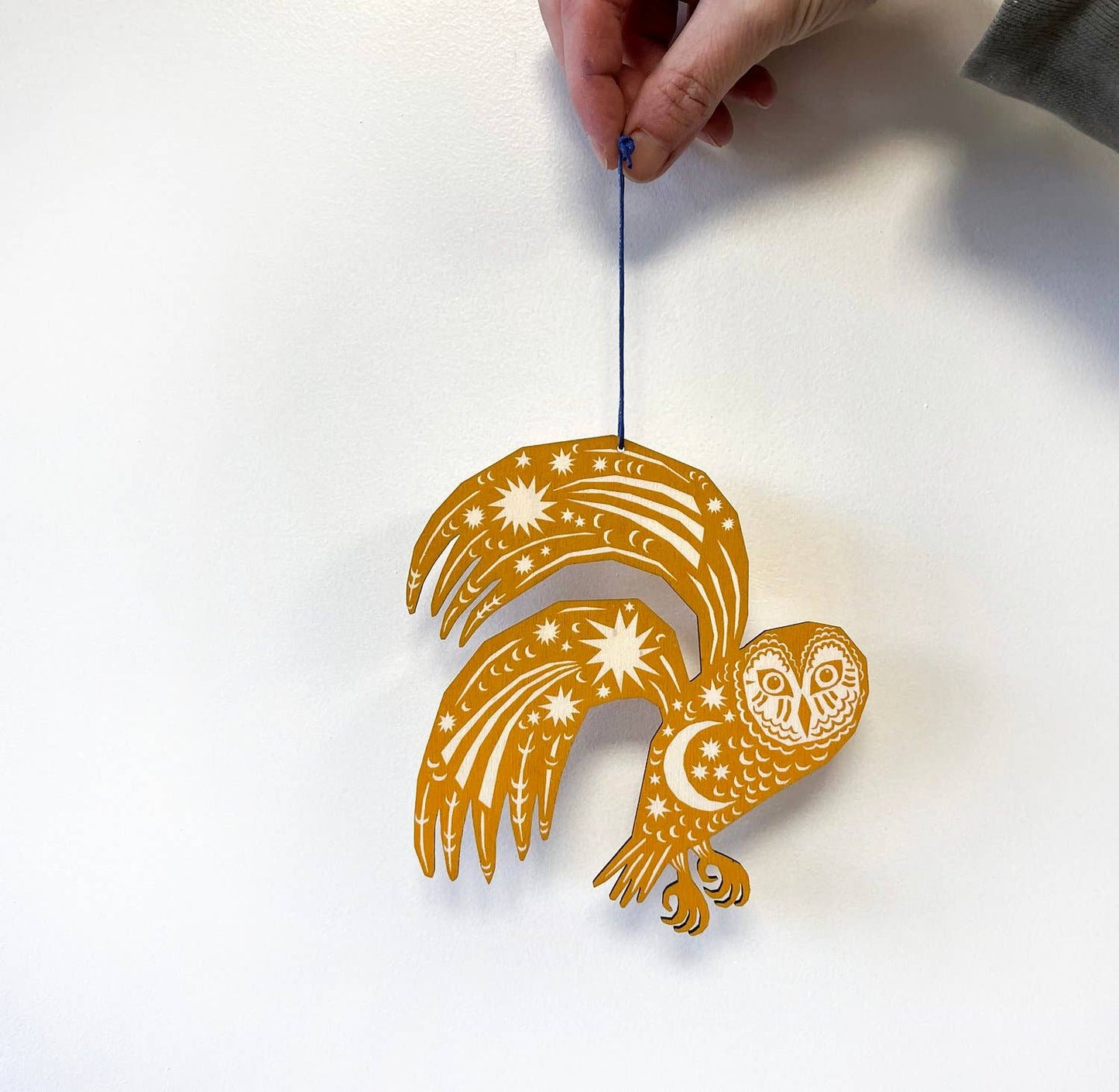 Decorative owl ornament with star patterns on a white background