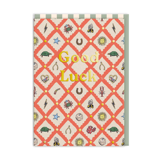 Greeting card with a multicolored pattern featuring various designs such as stars, hearts, and animals on a beige background, and the text 'Good Luck' on the front.
