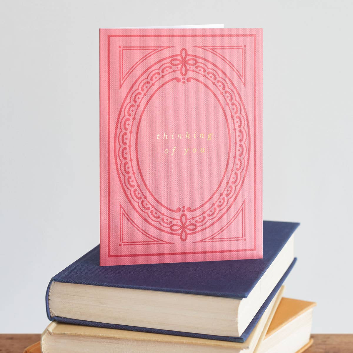 Pink greeting card with 'thinking of you' in gold foil