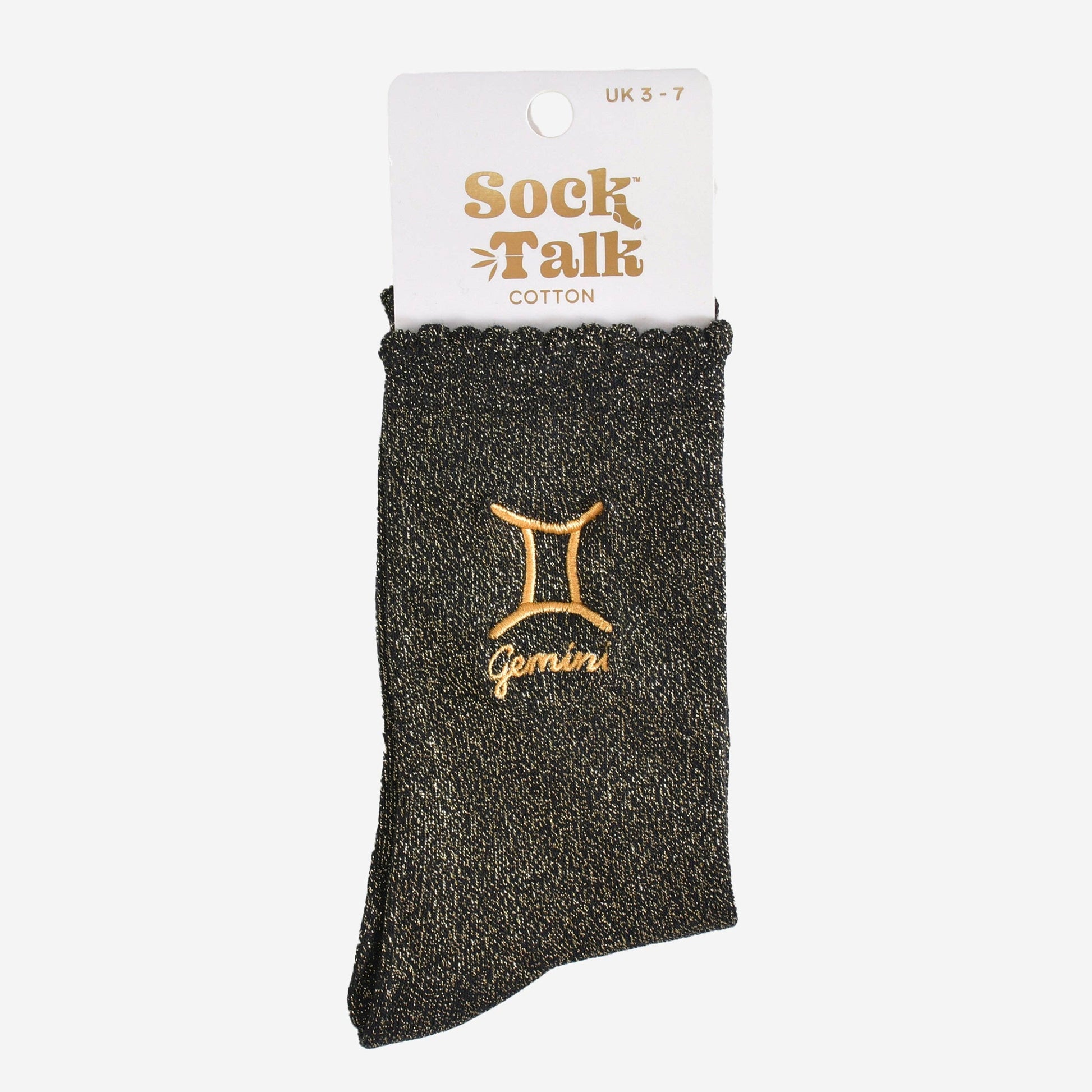 A pair of black socks with gold sparkle and the embroidered gold Gemini star sign, packaged in white and gold card.