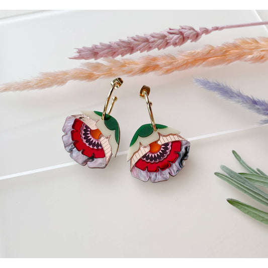 Floral earrings on a white surface with dried lavender and grasses.
