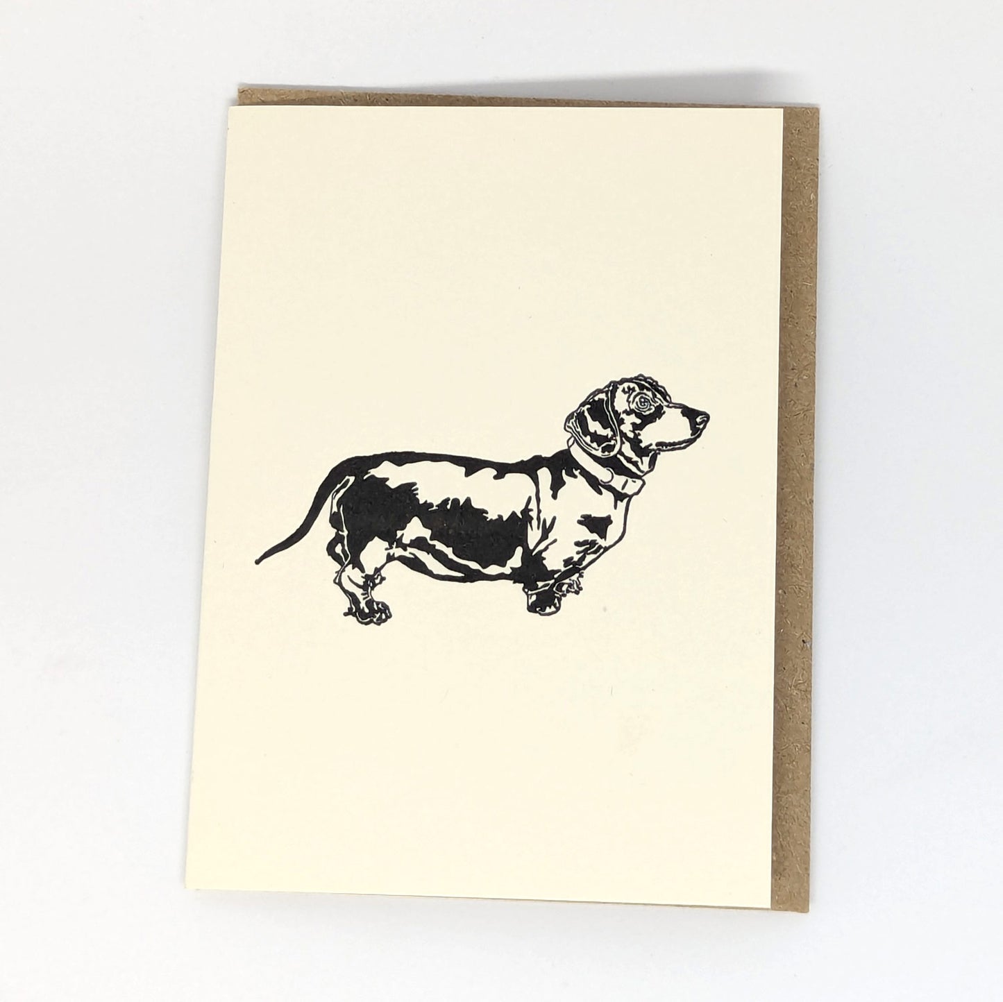 A greeting card with a letterpress illustration of a Dachshund dog.