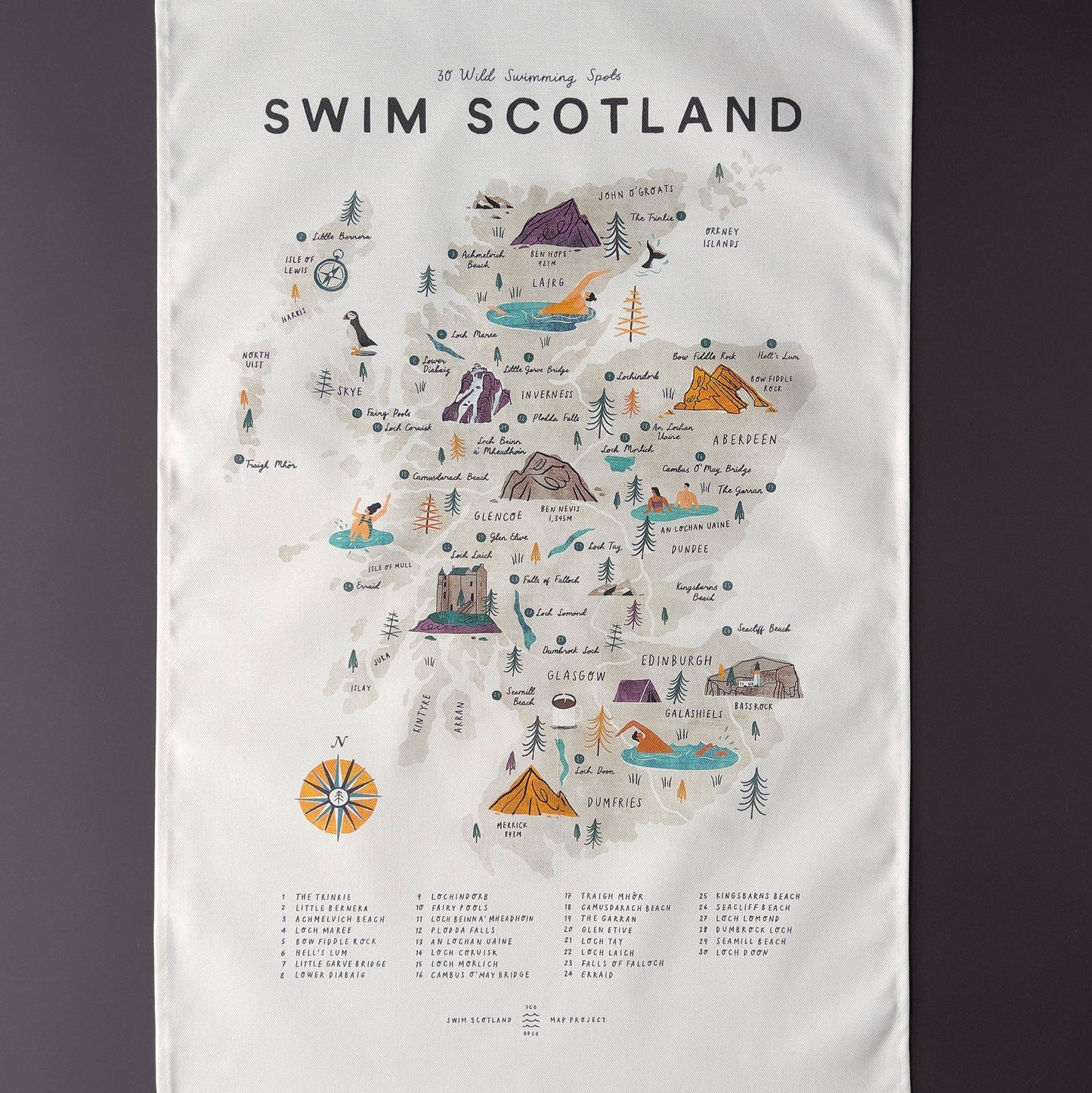 Tea towel with a map of Scotland featuring swimming locations on a white background.