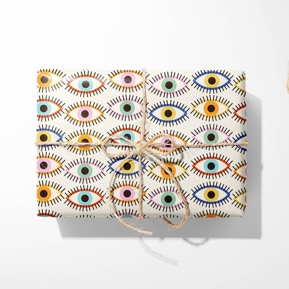 Colourful eye patterned gift wrapped parcel with twine