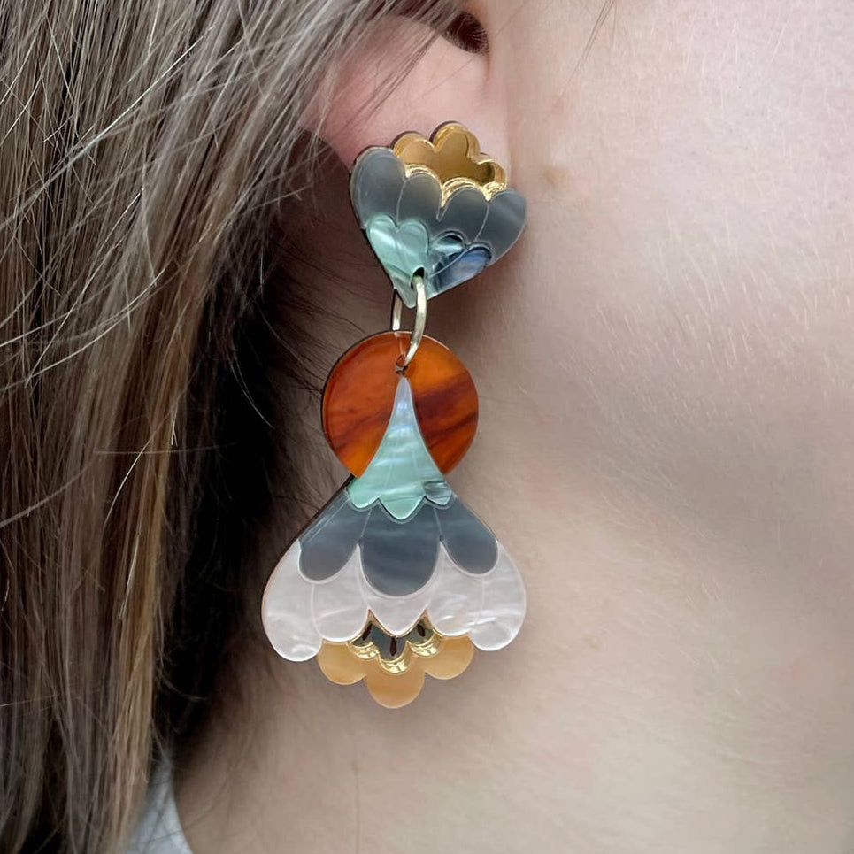 Close-up of colorful floral earrings worn by a person with long hair