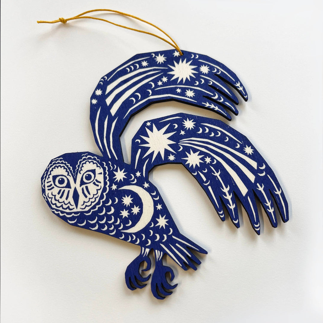 Decorative blue owl ornament with white patterns on a white background