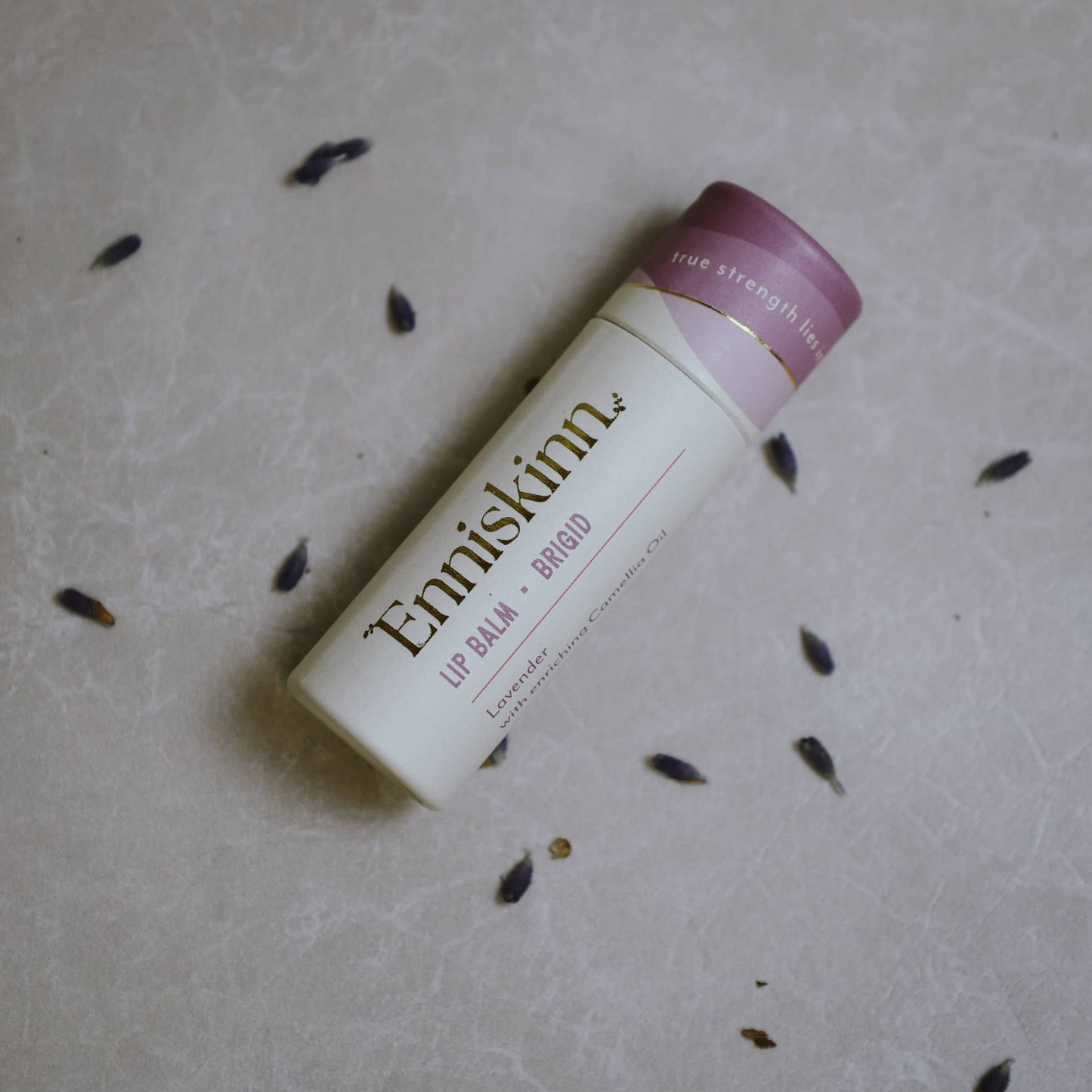 Lip balm with purple cap on a textured surface