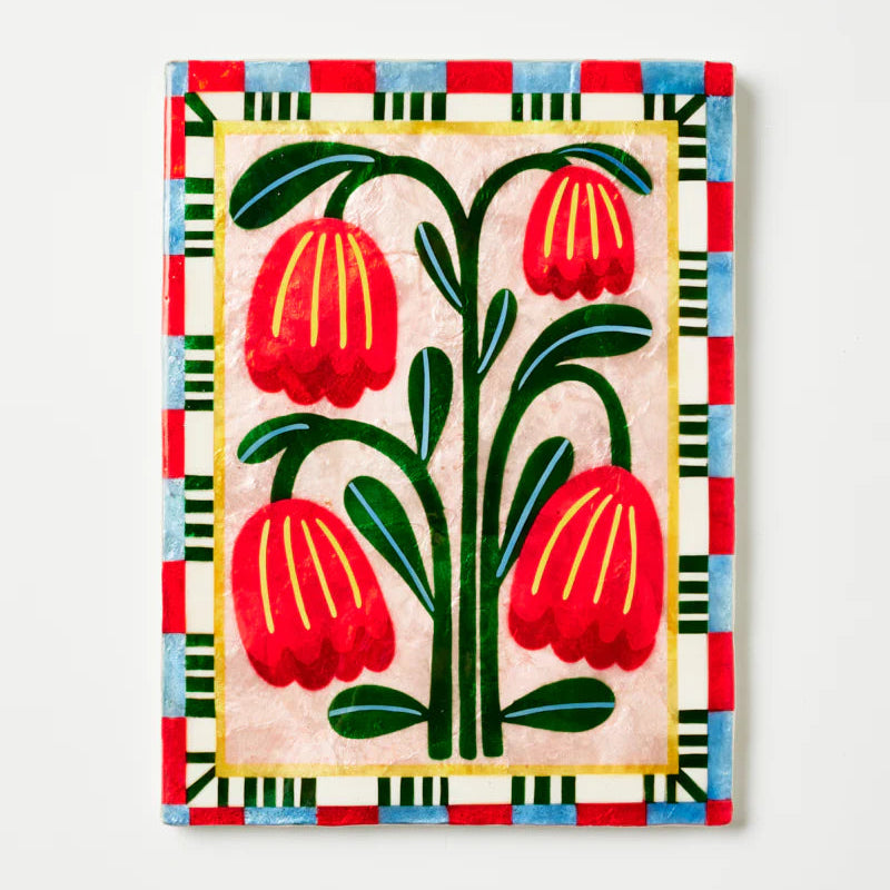 Decorative capiz shell wall art with red floral design on a light background