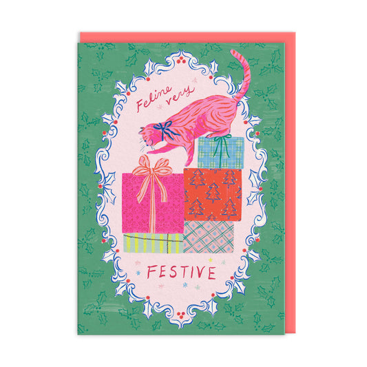 A vintage style colourful illustration of a cat playing with the ribbon on a present, surrounded by a frame of holly.