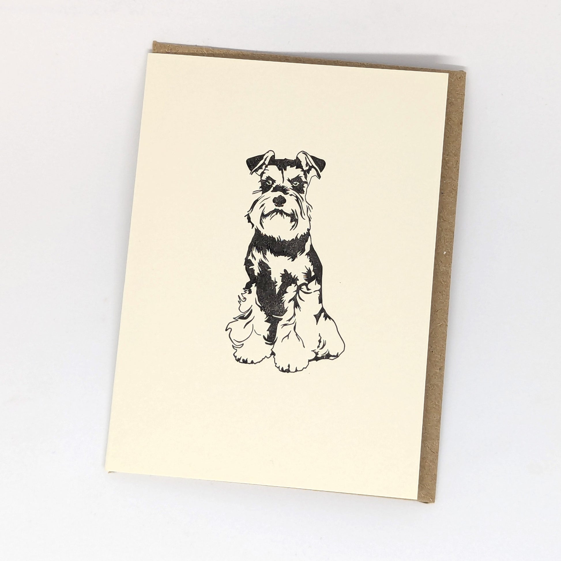 A letterpress greeting card featuring a black and white illustration of a Miniature Schnauzer dog,