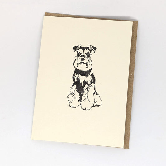 A letterpress greeting card featuring a black and white illustration of a Miniature Schnauzer dog,