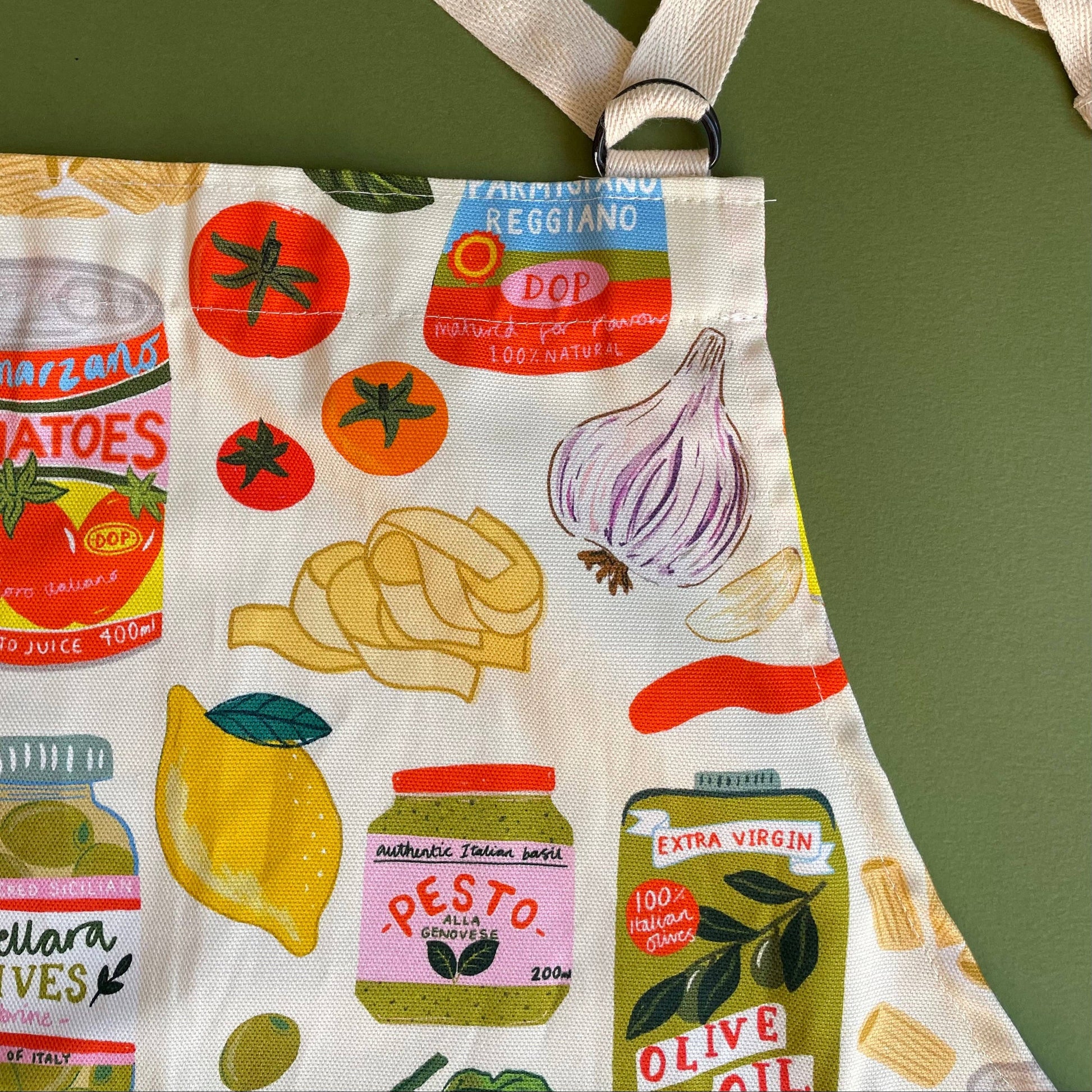 Fabric apron with italian food themed illustrations on a green background
