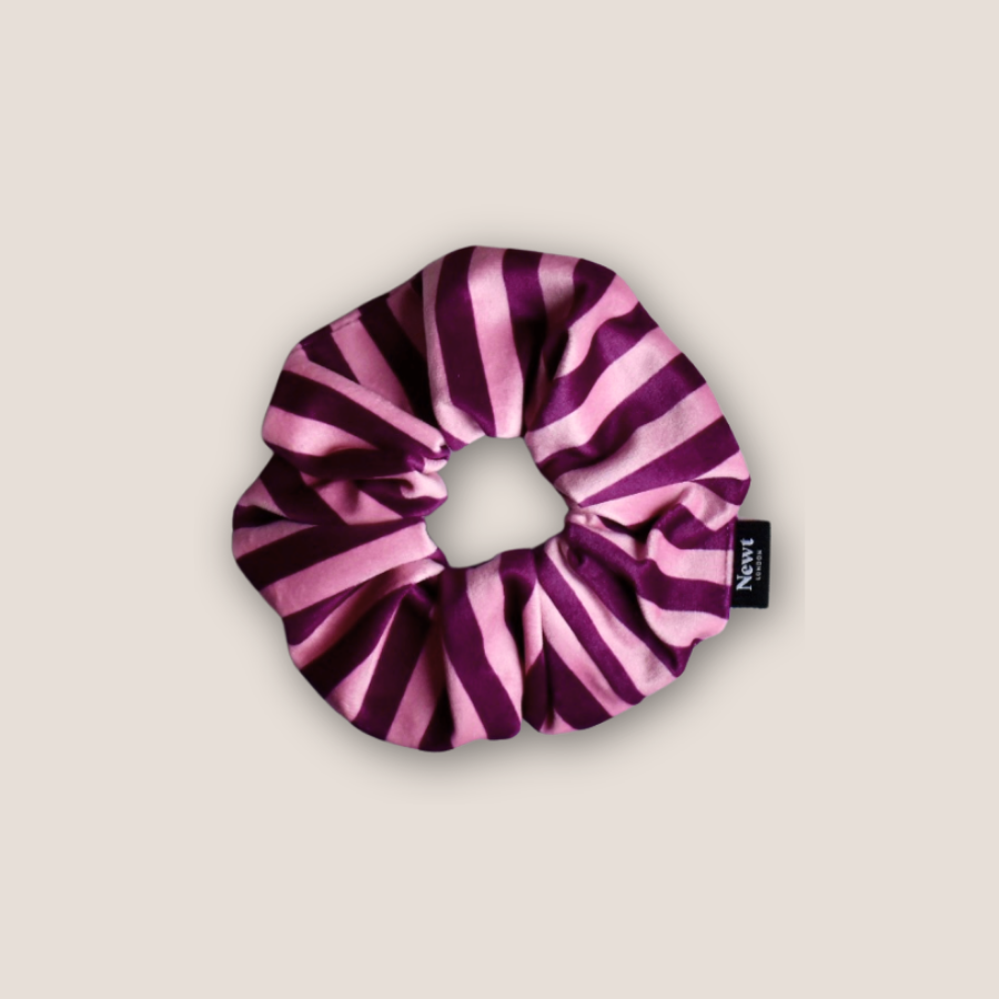 Purple and pink striped scrunchie on a beige background