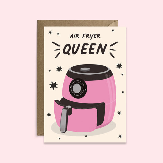 A greetings card with an illustration of a pink air fryer on the front, titled 'AIR FRYER QUEEN' in bold, decorative lettering. The card also features stars and a brown kraft envelope.