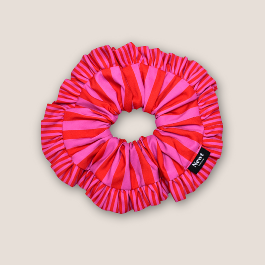 Pink and red striped scrunchie on a beige background