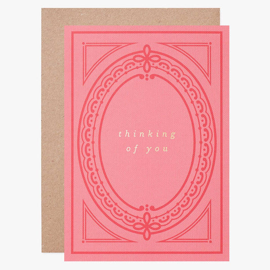 Pink greeting card with decorative border and 'thinking of you' text on a white background