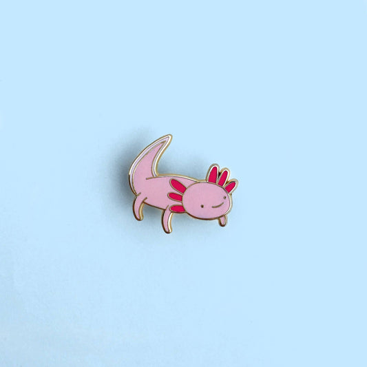 Pink axolotl enamel pin on a light blue background