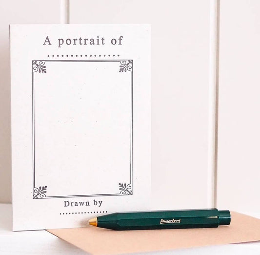 A portrait-style 'fill-in-the-blank' letter press card with a pen lying in front of it, indicating the card is designed for writing or drawing personal messages.