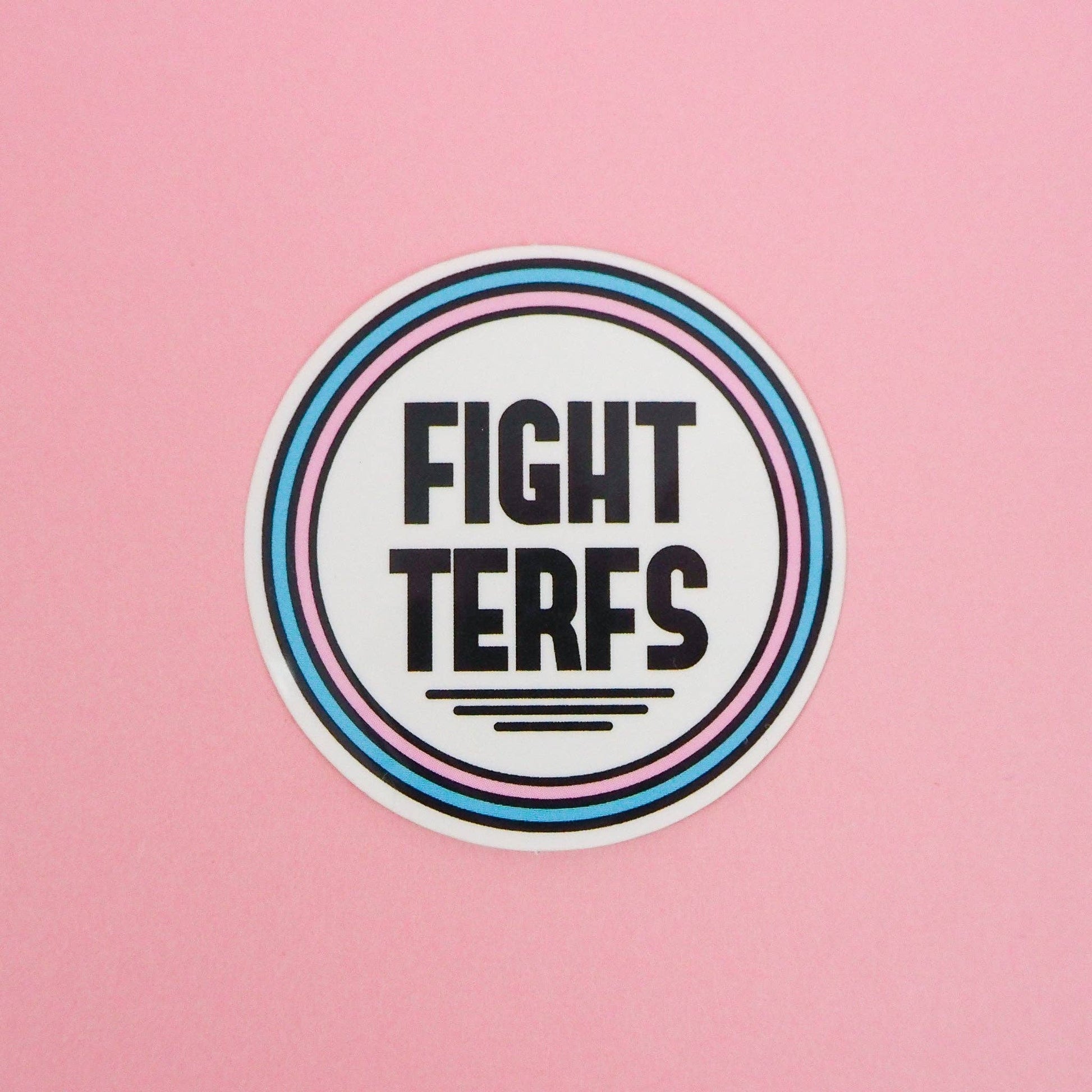 A vinyl sticker with a circular design featuring the text 'FIGHT TERFS' in bold letters
