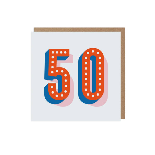 A 50th birthday card with the number 50 printed in bold blue and red letters, with dots on each number, presented on a white background with a kraft envelope.