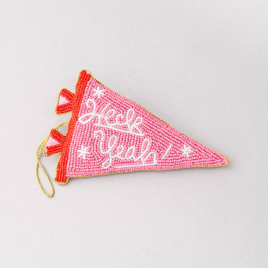 Pink beaded pennant with white text on a light pink background