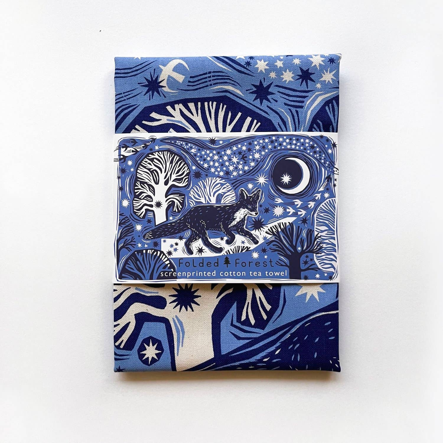 Folded tea towel with packaging showing a blue fox design