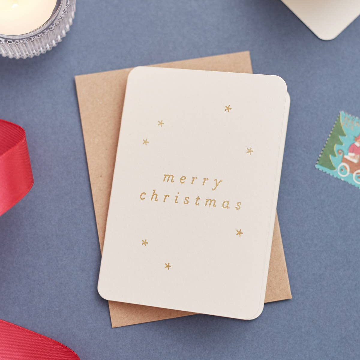 Christmas card pack with 'merry christmas' text in gold foil on a blue background