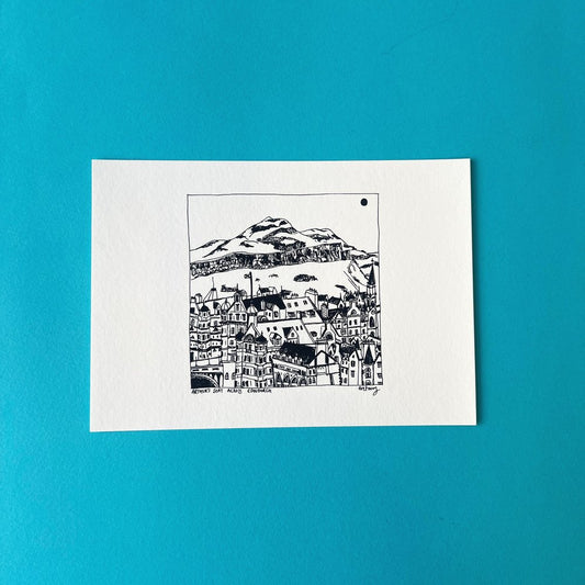 A line illustration of the Edinburgh skyline with Arthur's Seat mountain towering above the buildings, presented on fine art paper.