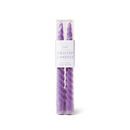 Purple twisted candles in packaging on a white background