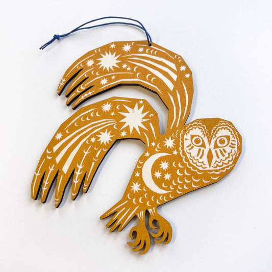 Decorative owl ornament with star and moon patterns on a white background