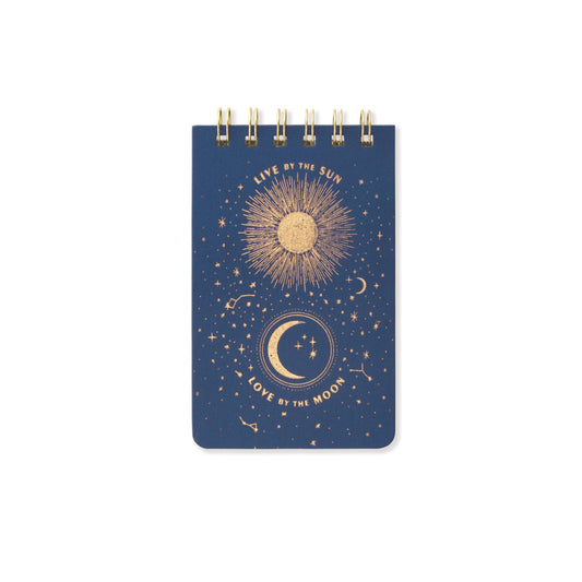 a blue notebook with live by the sun love by the moon written onm it in gold foil