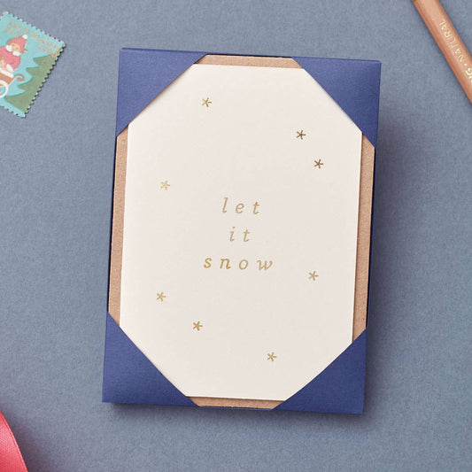 Christmas card pack with 'let it snow' text in gold foil on a blue background
