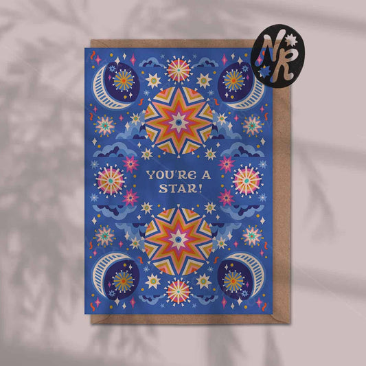 Greeting card with star and moon designs on a blue background, featuring the text 'You're a Star!'.