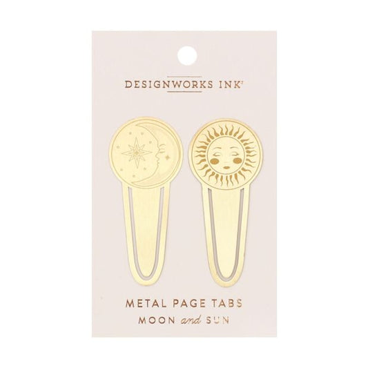 A set of two gold-colored metal page tabs, one engraved with a sun design and the other with a moon design, attached to a cardboard header.