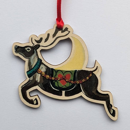 Wooden reindeer ornament with a red ribbon on a white background