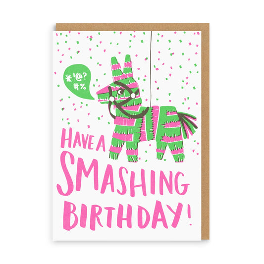 A colorful greeting card with an illustration of a pinata donkey and the text 'HAVE A SMASHING BIRTHDAY!' on the front, with a small heart-shaped balloon and a green, pink, and white patterned background.