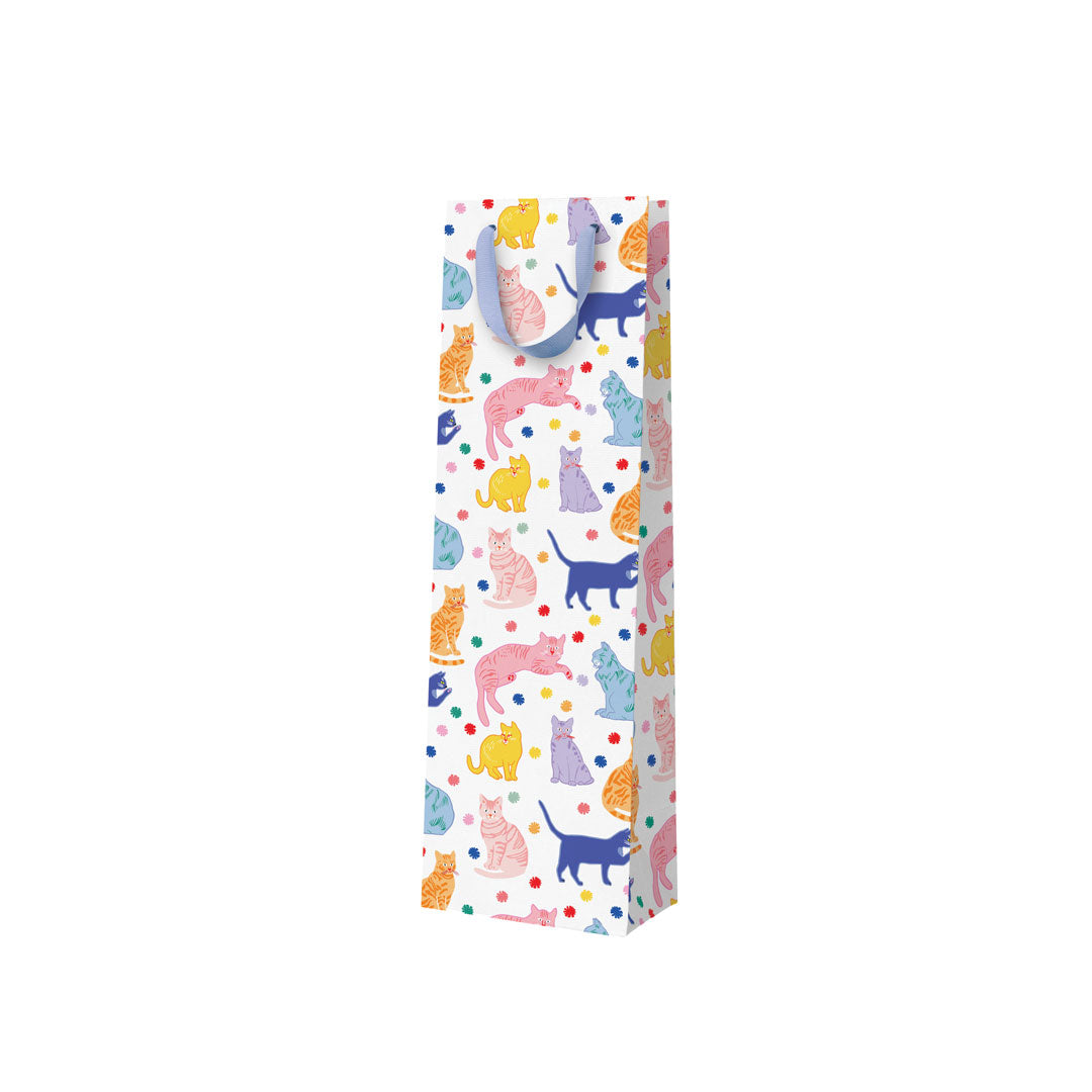 A white bottle sized gift bag with a blue ribbon handle and a colourful print featuring lots of unusually coloured cats - pink, blue, yellow 