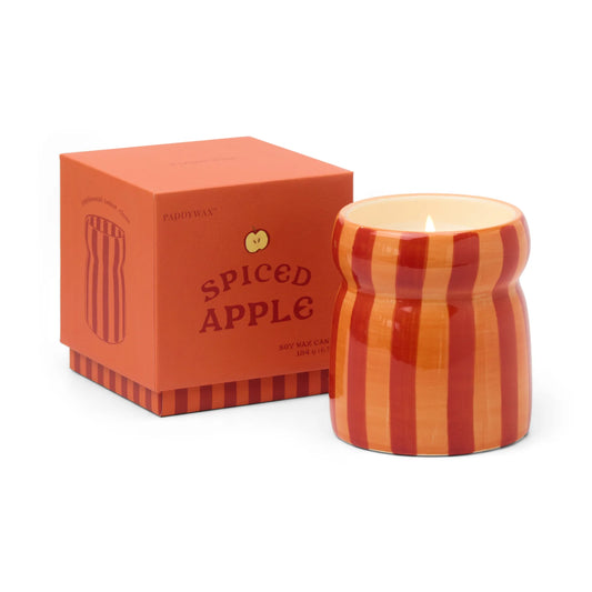 Striped candle with 'Spiced Apple' packaging on a white background