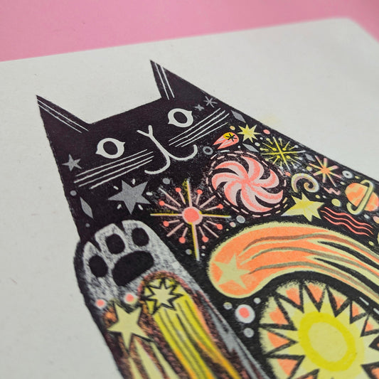A colorful art print of a cat with star patterns and a whimsical design.